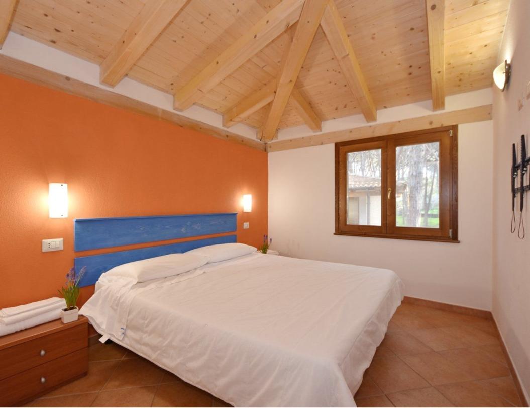 Camera da letto accogliente con soffitto in legno e parete arancione.
